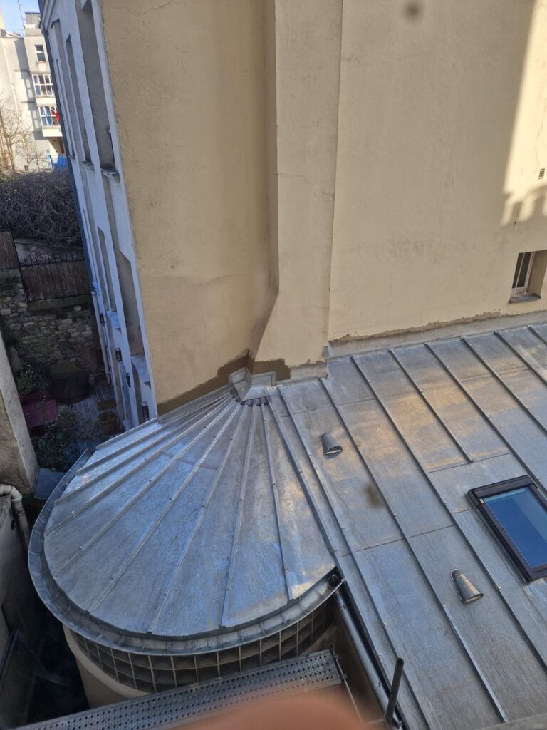 Vue sur toiture zinc et cour intérieure.
